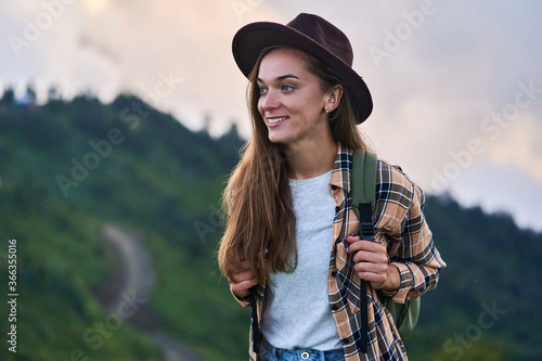 Portrait of free happy smiling attractive backpacker woman traveler during traveling alone in the mountains photo