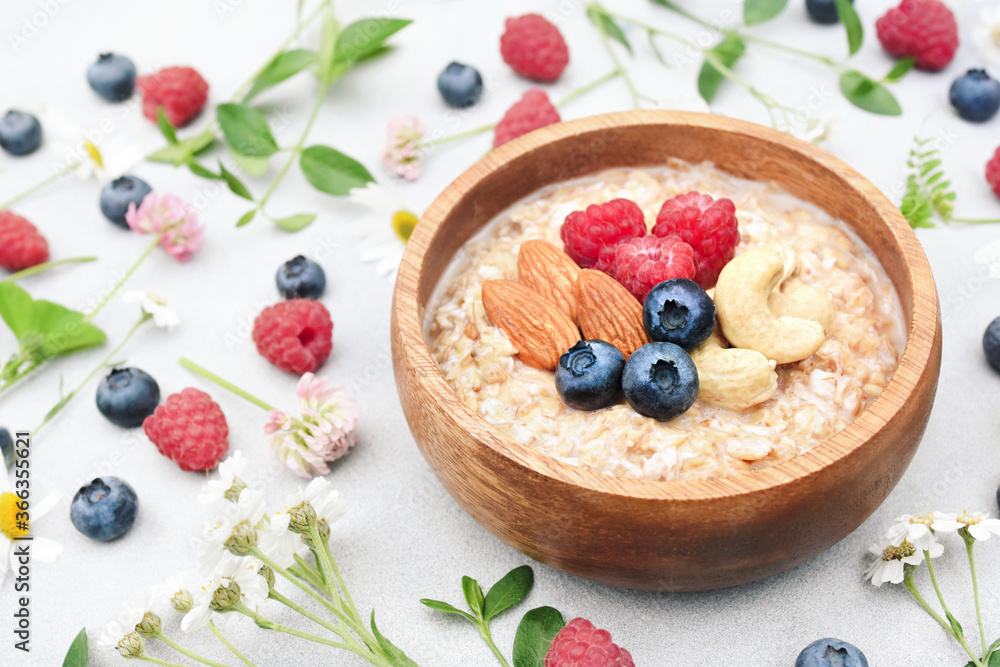 Morning oat with raspberry, blueberry and nuts, summer vegan oatmeal for healthy diet, selective focus Morning oat with raspberry, blueberry and nuts, summer vegan oatmeal for healthy diet, selective focus