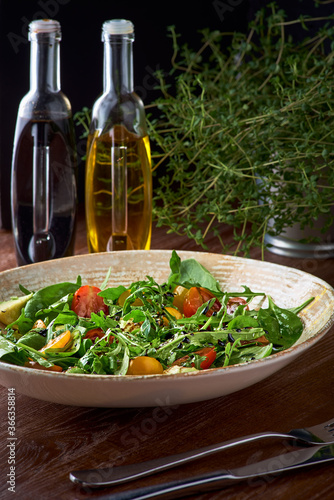 Nutritious low calorie organic vegetable salad made from green leaves and tomato and avocado seasoned with olive oil