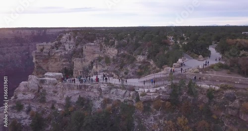 Aerial of People standing on Ledge in Gran Canyon watching the Beautiful view while camera make Parallax around the Ledge revealing the Canyon