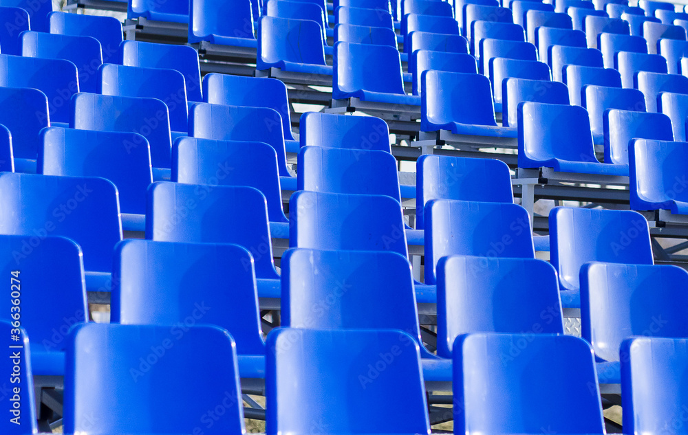 Fototapeta premium Background of blue plastic seats in the stands. Empty seats in the stadium. Places for fans and spectators.