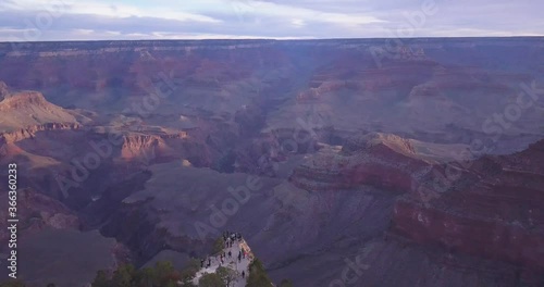 Aerial of  Grand Canyon while camera moving Backwards revealing People standing on Ledge and watching the Beautiful view 