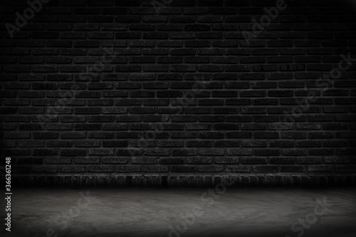 Empty black brick wall and concrete floor for background. Dark room interior with black brick wall blank cement floor for backdrop.