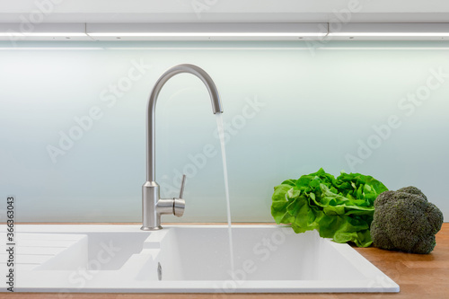 Fototapeta Kitchen faucet turned on