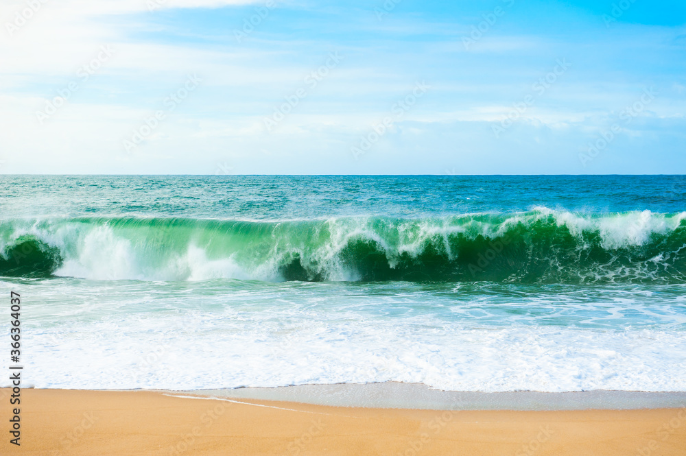Waves on the coast of Atlantic ocean. Algarve, Portugal. Beautiful beach with white sand and turquoise water. Summer nature background.