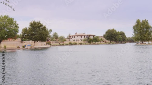 Wallpaper Mural Dolly right past tall grass at the edge of a lake to reveal the lake with a mansion on the far edge of the shore on a cloudy day in Arizona. Torontodigital.ca