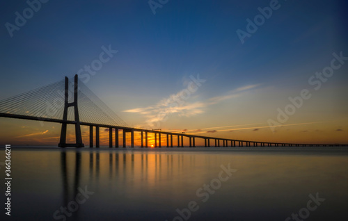 Fototapeta Naklejka Na Ścianę i Meble -  Beautiful sunrise at Vasco da Gama Bridge, the longest bridge in Europe, who spans the Tagus River in Lisbon, Portugal.