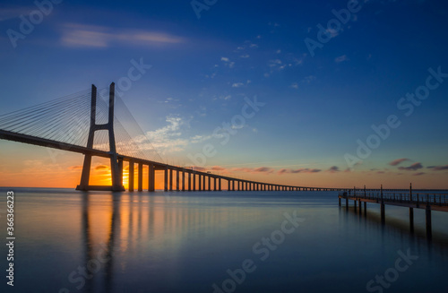 Fototapeta Naklejka Na Ścianę i Meble -  Beautiful sunrise at Vasco da Gama Bridge, the longest bridge in Europe, who spans the Tagus River in Lisbon, Portugal.