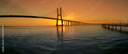 Beautiful sunrise at Vasco da Gama Bridge, the longest bridge in Europe, who spans the Tagus River in Lisbon, Portugal.