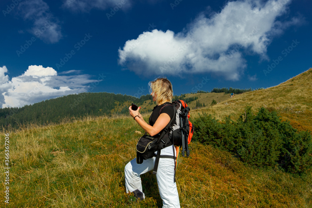 girl with a backpack and a smartphone in the carpathians