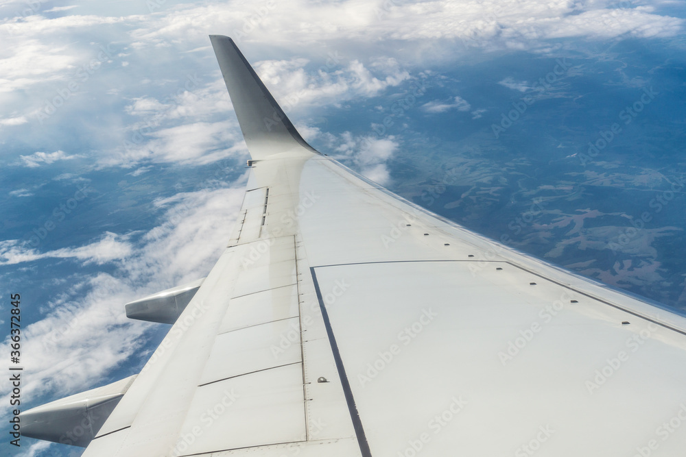 Airplane wing in flight above the clouds, horizon of the earth. Air travel concept Airplane wing in flight above the clouds, horizon of the earth. Air travel concept