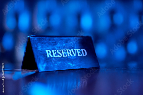 Reserved plate on night club, reserved sign. Blue light. photo