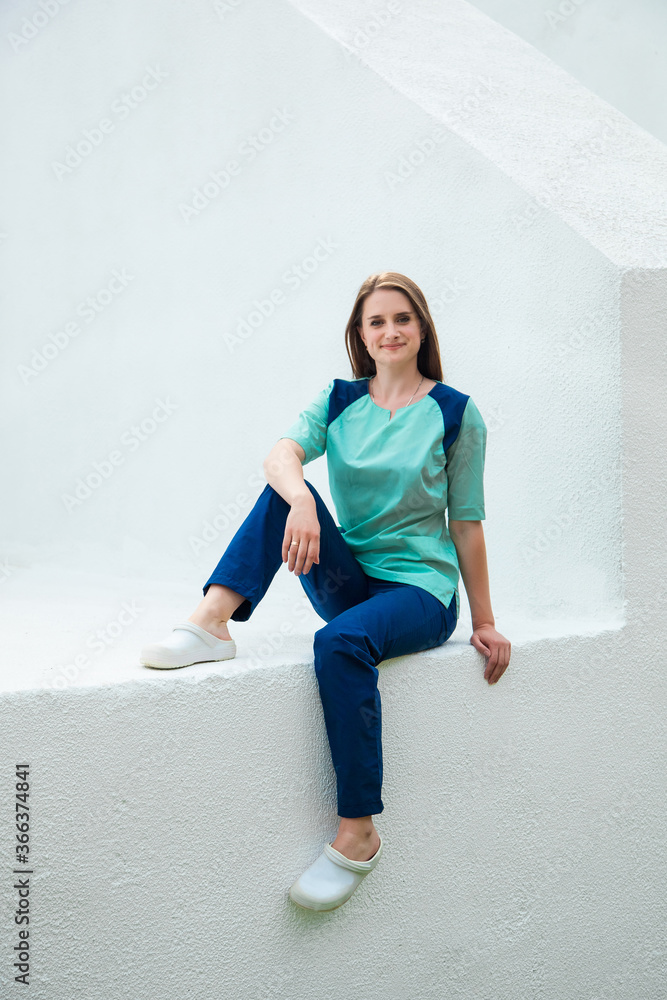 Fototapeta premium Medical student on the background of a school of nursing in a blue surgical suit. Young traumatologist doctor.