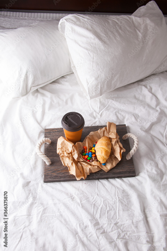 Romantic breakfast with flower branch in bed on wooden tray with corn flakes, fruits, milk, eggs and coffe. Window light, copy space Romantic breakfast with flower branch in bed on wooden tray with corn flakes, fruits, milk, eggs and coffe. Window light, copy space
