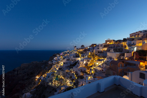 Santorini, Oia, Night view of the illuminated village on the cliff above the Caldera. Beautiful romantic and quiet atmosphere.