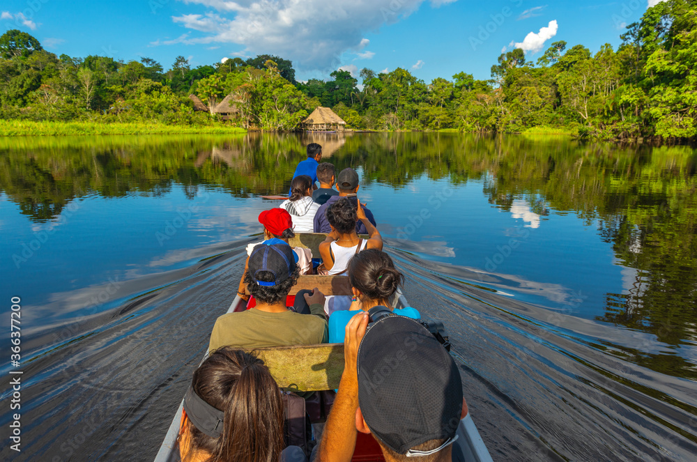 Transport in canoe along the rivers of the Amazon River Basin inside Yasuni  National Park with a lodge in traditional architecture style, Ecuador.  Photos | Adobe Stock