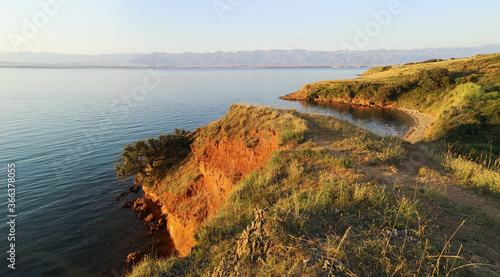 Panoramic view of orange rocky cliffs and Adriatic sea. Island Vir in Croatia on sunset.