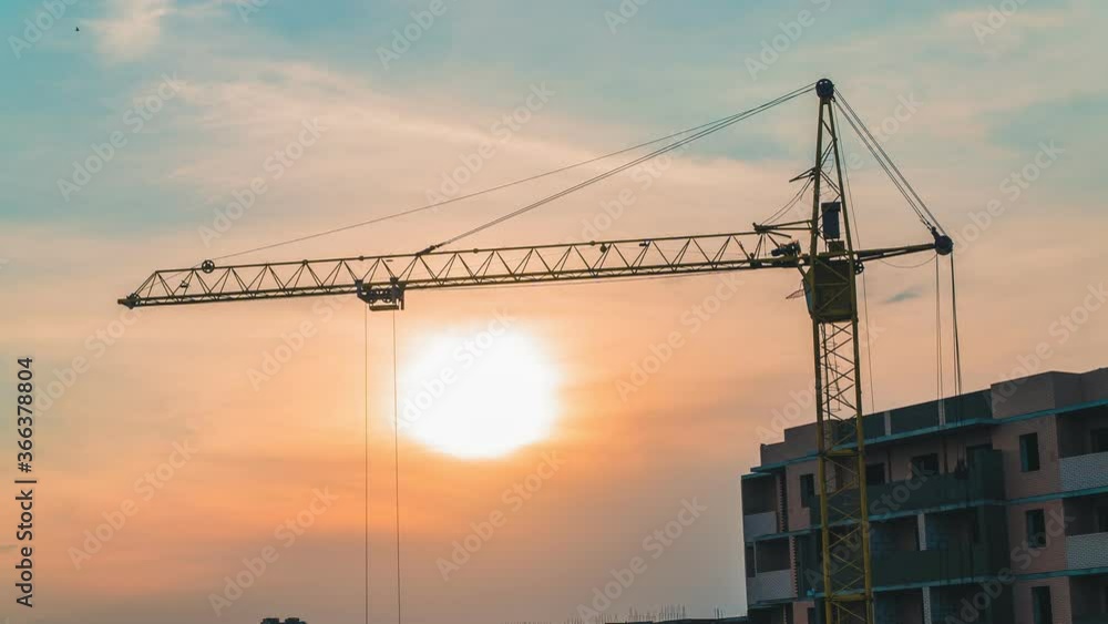 Timelapse of a working construction crane on a background of sunset. Building Timelapse of a working construction crane on a background of sunset. Building