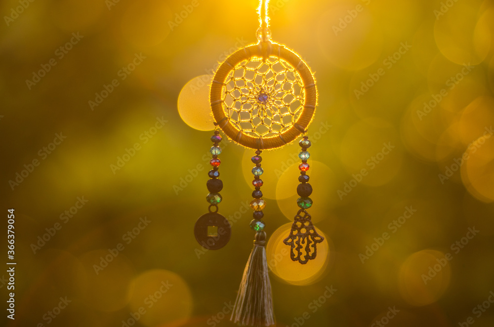 Close up of spiritual necklace with sacred geometry circle with bokeh background backlit by sunset golden light Close up of spiritual necklace with sacred geometry circle with bokeh background backlit by sunset golden light