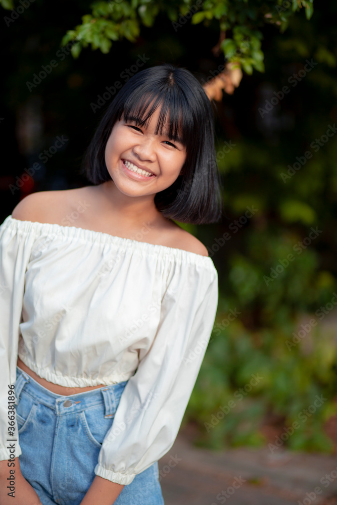 toothy smiling face of asian teenager standing outdoor