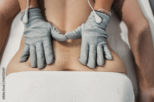 Micro sensory electrical BIO EMS microcurrent treatment for face and body electro stimulation and muscle toning. Anti wrinkle and anti-aging lifting. Alternative therapy with conductive gloves. photo