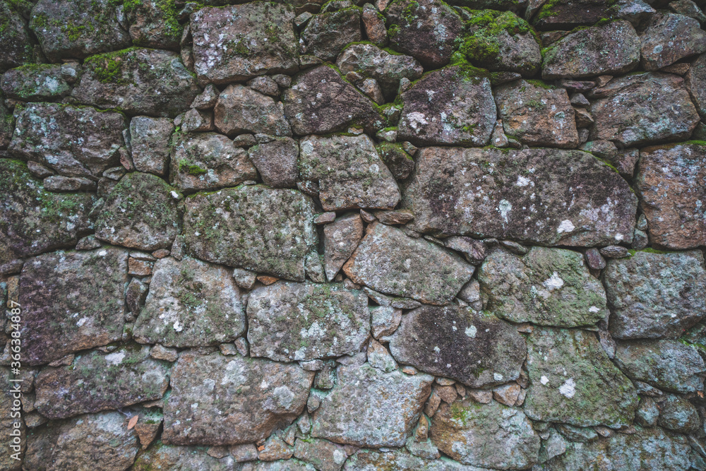 Old real stone wall surface texture. Pattern white, yellow modern style design decorative uneven cracked rocks. 