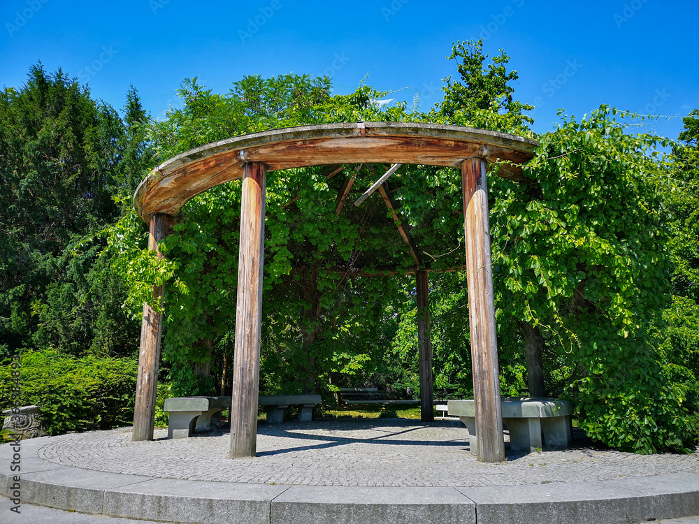 Old round construction in park with ivy and bushes around