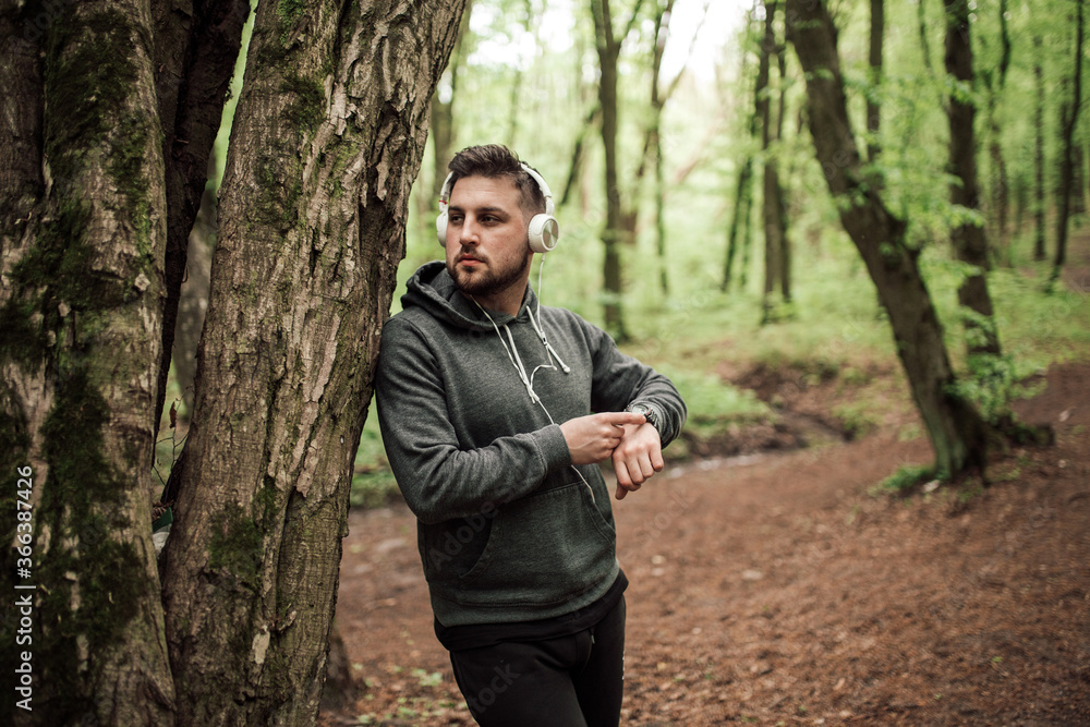 Adult sporty man in forest, park running in the morning Adult sporty man in forest, park running in the morning