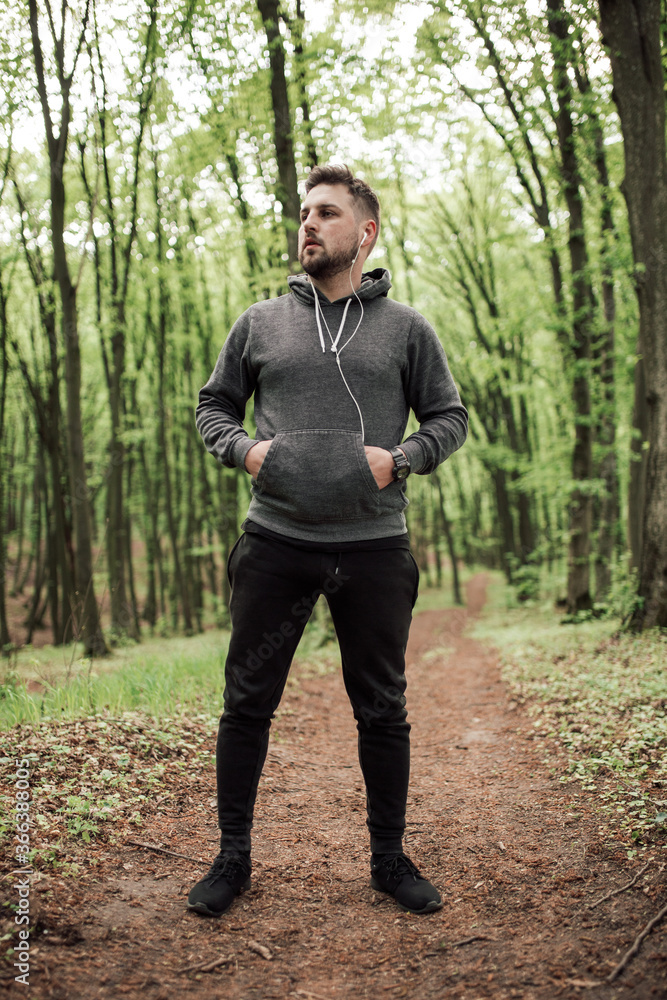 Adult sporty man in forest, park running in the morning Adult sporty man in forest, park running in the morning