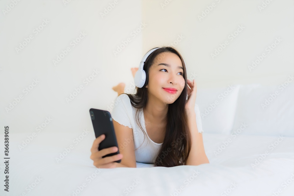 Portrait beautiful young asian woman happy smile with smart mobile phone and headphone for listen music Portrait beautiful young asian woman happy smile with smart mobile phone and headphone for listen music