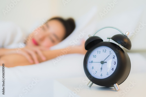 Portrait beautiful young asian woman sleep on bed with clock
