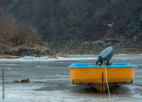 Fishing boat  on ice covered river. photo