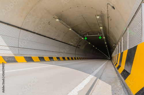 Two lane highway tunnel of white concrete
