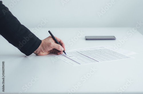 Mano de hombre de negocios firmando un documento oficial. Hombre firmando el contrato en una mesa blanca. photo