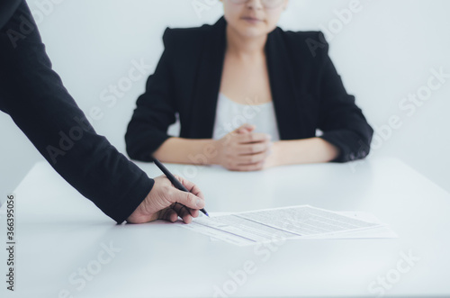 Mujer de negocios en la sala de juntas observa al cliente firmar el contrato. Personas de negocios firman el contrato en un escritorio blanco.