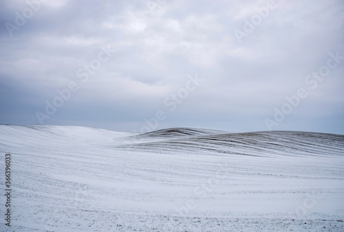 Field and hills covered with snow. cold frosty sunrise on swamp