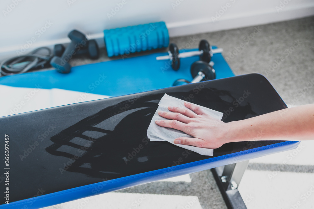 the new normal after covid19, hand cleaning gym equipment with