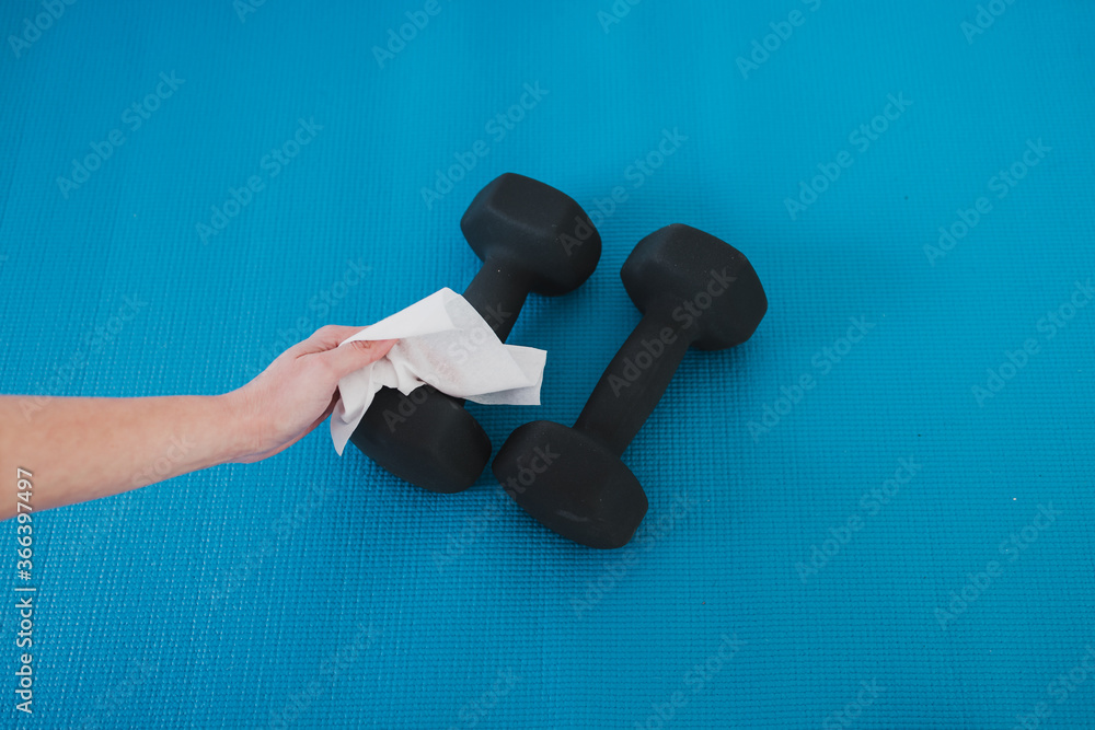 the new normal after covid19, hand cleaning gym equipment with
