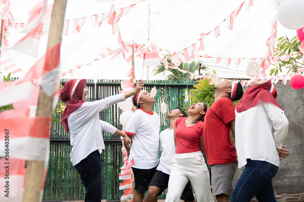 asian young men and young women joined in cracker eating contest in the celebration of August 17 Indonesian Independence Day