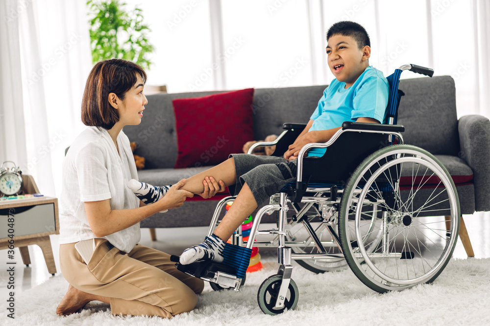 Portrait of asian physiotherapist carer helping and playing with special disabled child health problem by doing exercises sitting in wheelchair in rehabilitation clinic.disability care concept Portrait of asian physiotherapist carer helping and playing with special disabled child health problem by doing exercises sitting in wheelchair in rehabilitation clinic.disability care concept