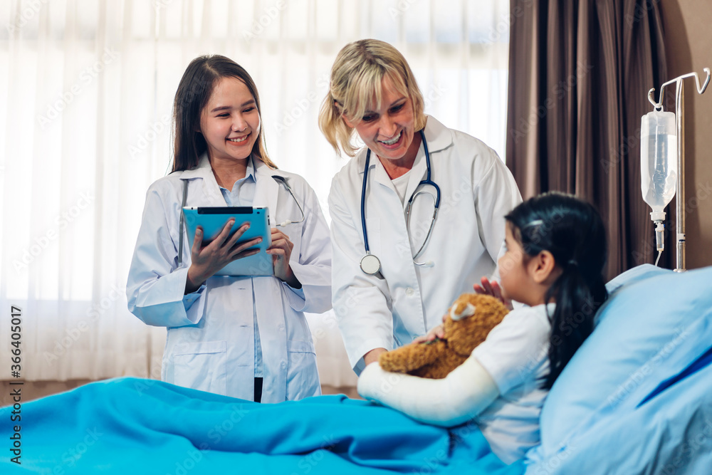 Obraz premium Smiling woman doctor service help support discussing and consulting talk to little girl patient give teddy bear and check up information in hospital