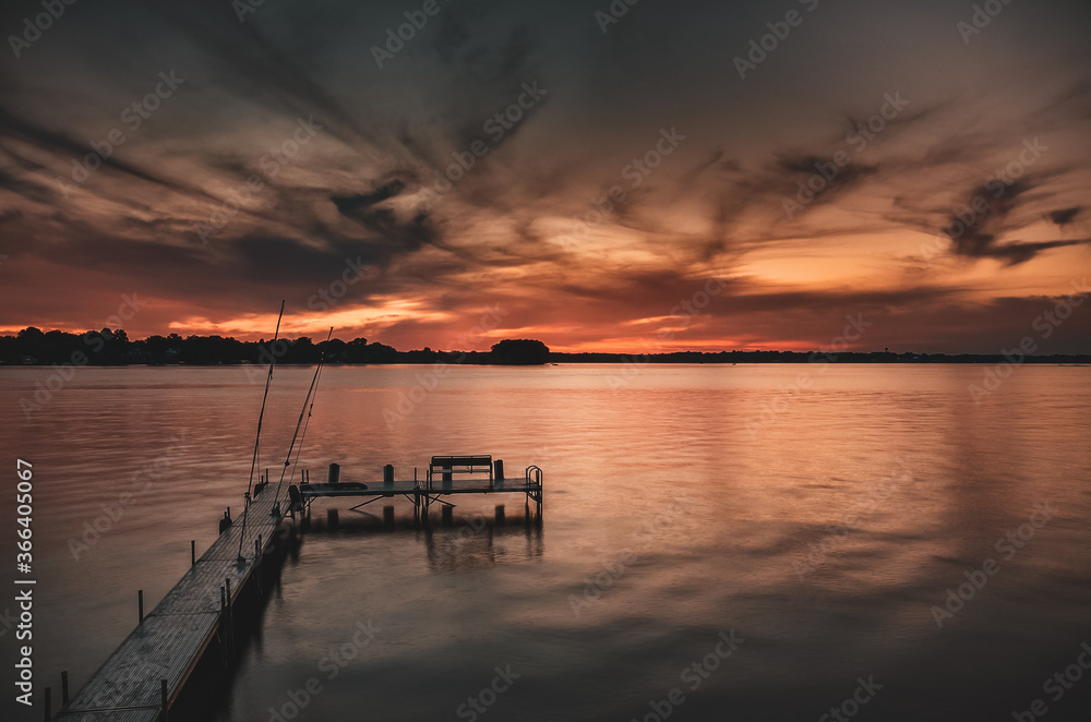 Sunset on lake overlooking a boat and fishing dock