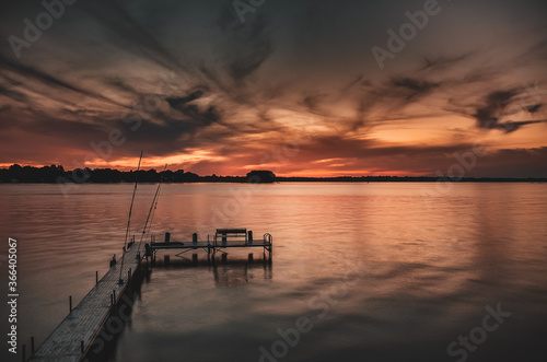 Sunset on lake overlooking a boat and fishing dock