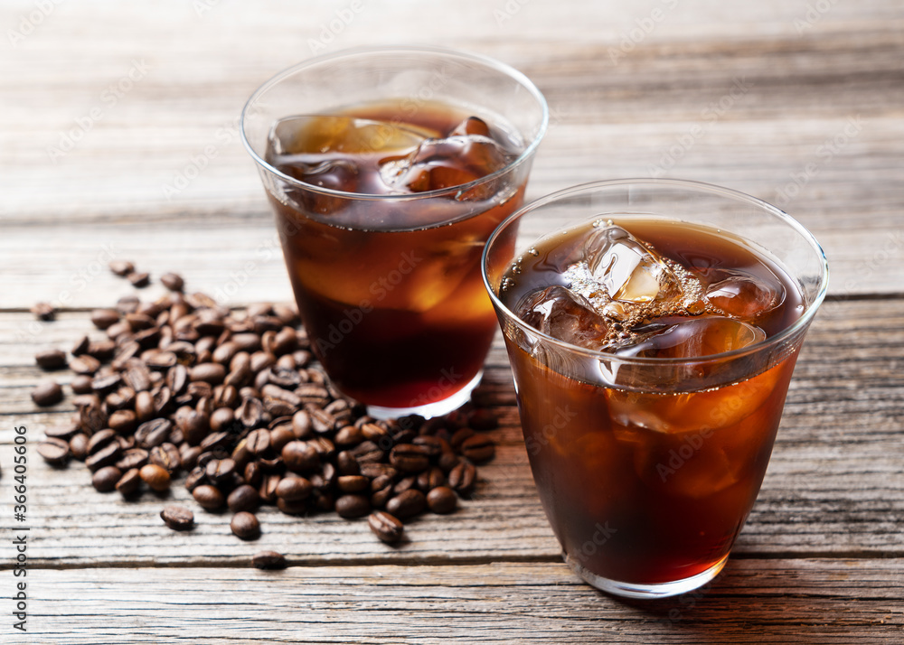Cold coffee in a glass with coffee beans behind it. Cold coffee in a glass with coffee beans behind it.