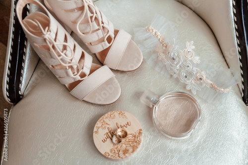 beige shoes for the bride, wedding rings, perfume, garter.