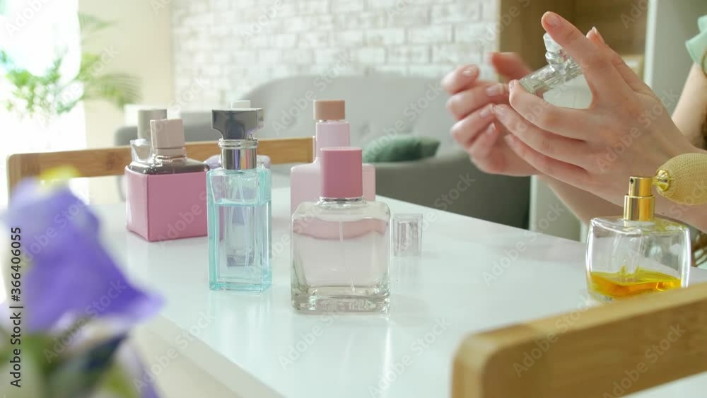 Young woman with different bottles of perfume at home Young woman with different bottles of perfume at home