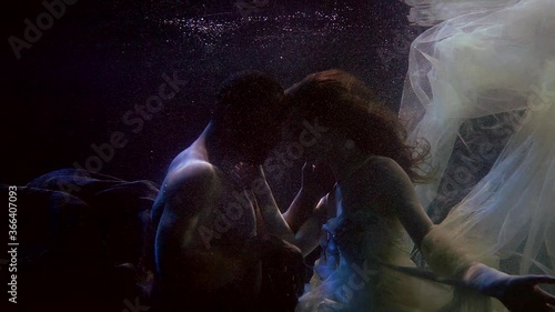 multiracial loving pair underwater, swimming and embracing, love and passion photo