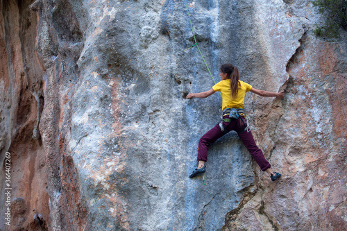 A strong woman climbs a rock, Rock climbing in Turkey.