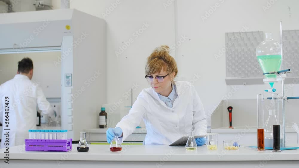 Chemist working with hemp CBD oil and tablet in laboratory Chemist working with hemp CBD oil and tablet in laboratory