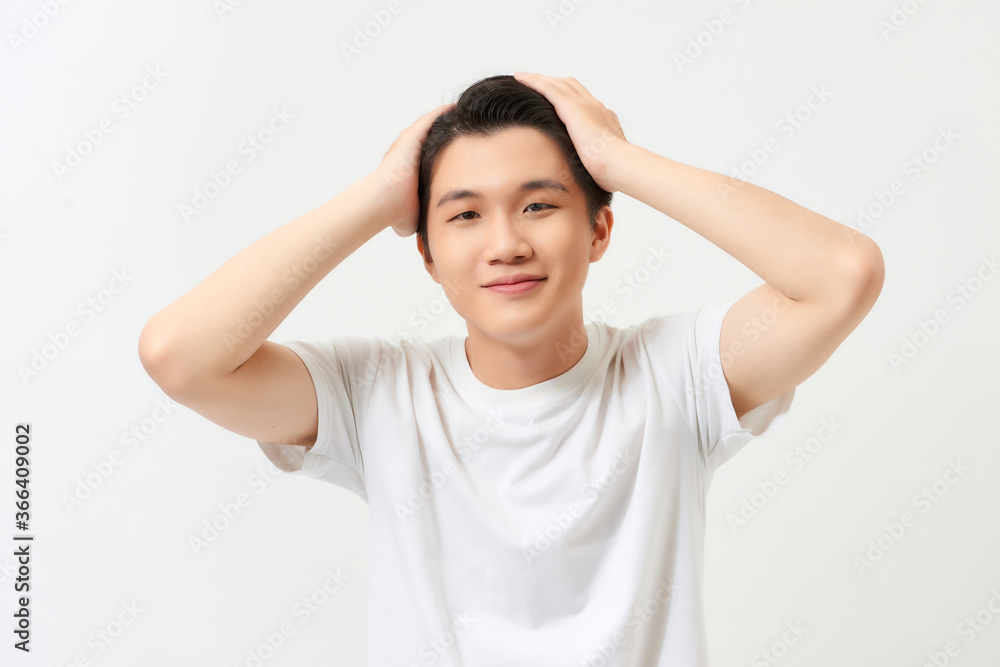 Flirty handsome. Portrait of handsome young beard man looking at camera and touching his hair with hands